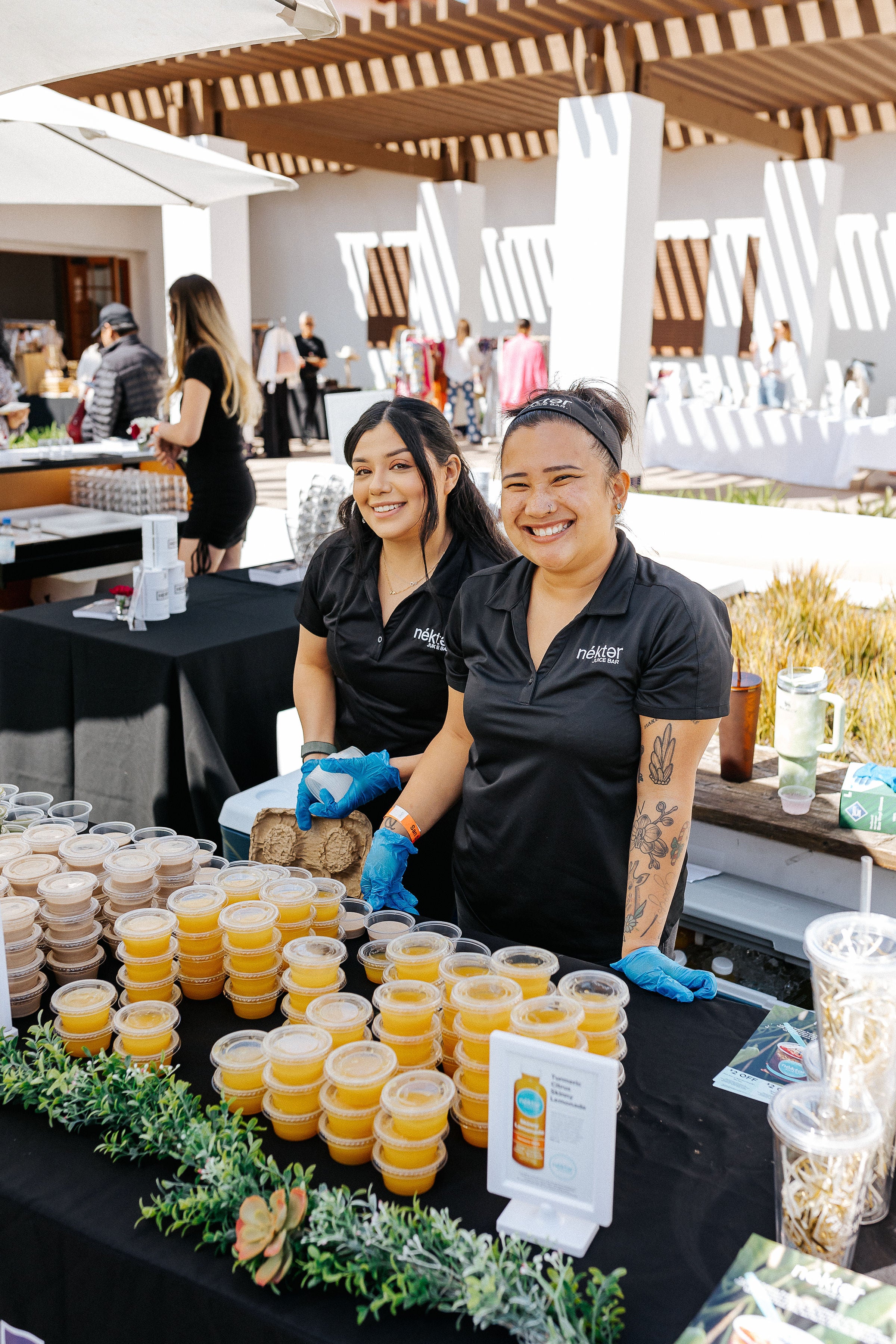 2 nekter staff members behind sample cups