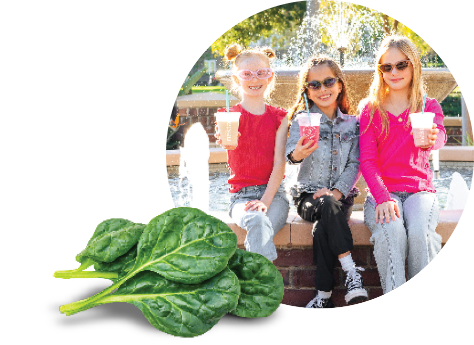 3 kids drinking smoothies in front of a fountain