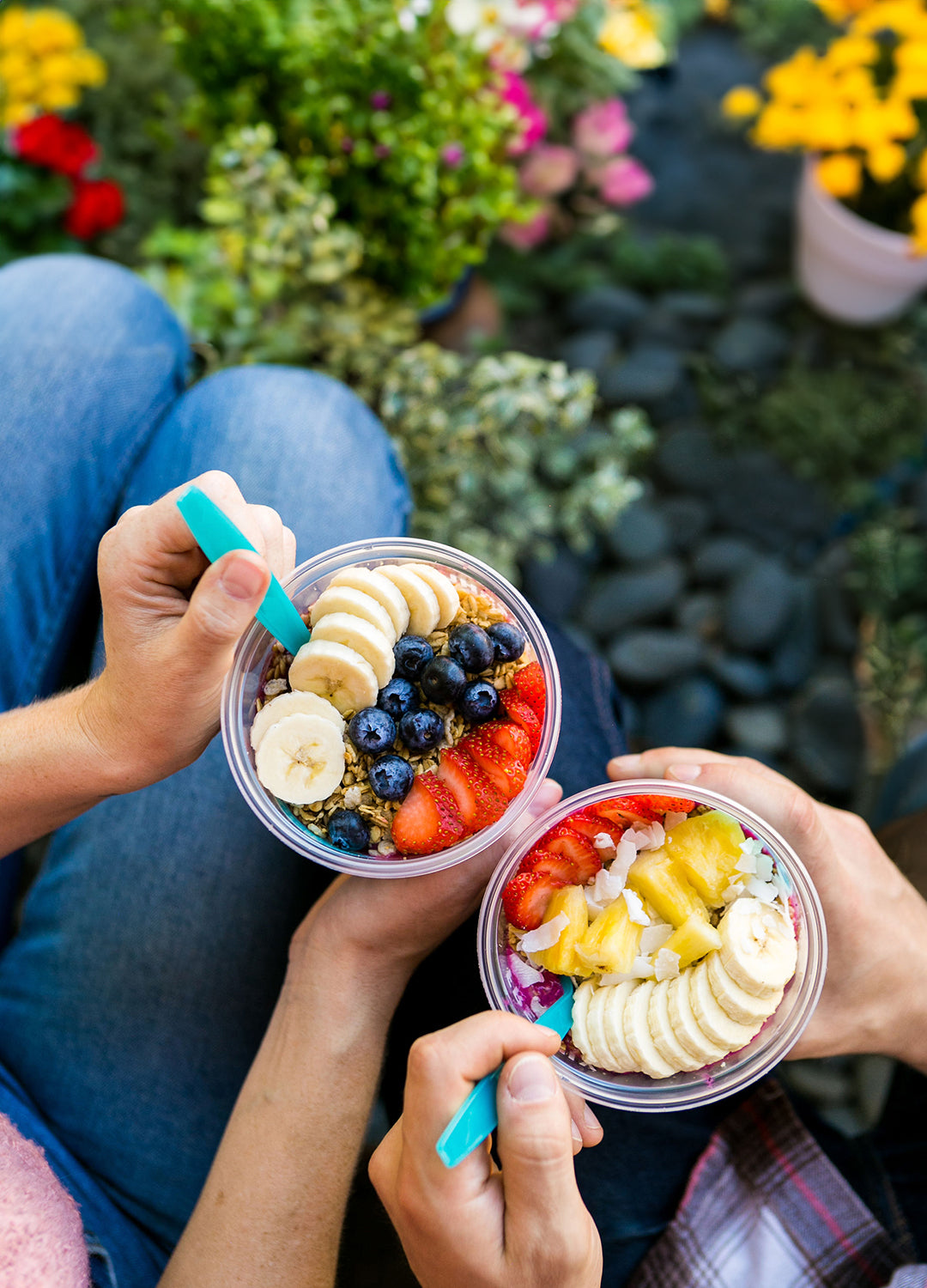 2 acai bolws being enjoyed in a garden