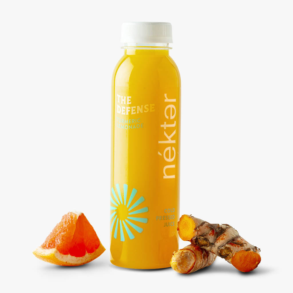 The Defense Juice shown with grapefruit and turmeric ingredients