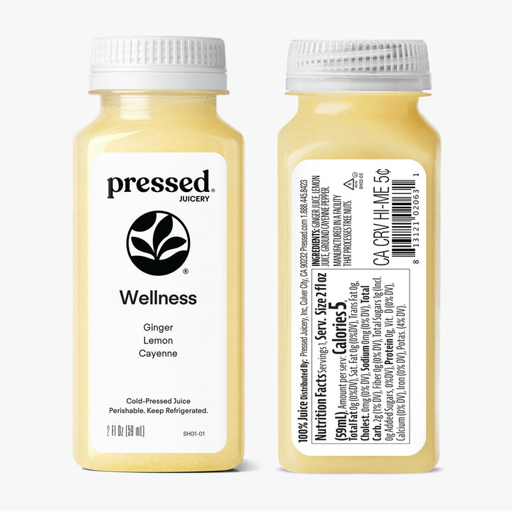 Two bottles of 'pressed' Juicery Wellness Ginger Lemon Cayenne juice on a white background
