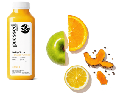 Bottle of 'Pressed Juicery' Daily Citrus juice with sliced oranges, apples, and a pumpkin on a white background.