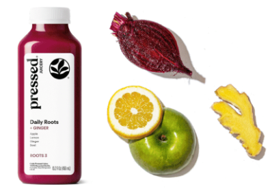 Bottle of 'pressed' juice with ingredients including a beet, lemon, and apple on a white background