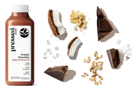 Bottle of 'pressed' protein smoothie with dark chocolate flavor, surrounded by chocolate pieces and nuts on a white background.