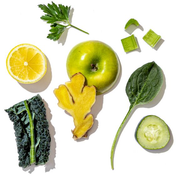 Collection of green fruits, vegetables, and herbs on a white background