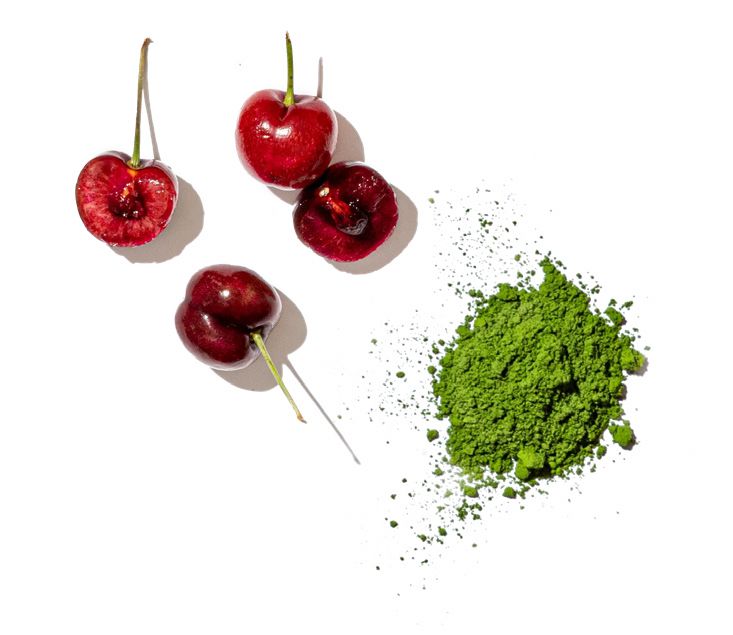Red cherries and green matcha powder on a white background