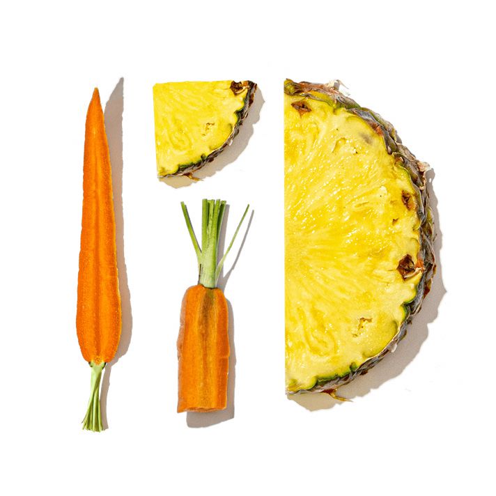 Sliced pineapple and carrots on a white background
